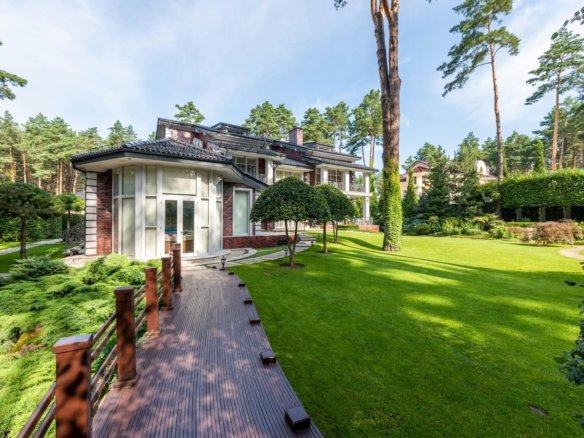 Elegant modern villa surrounded by lush greenery in a tranquil forest setting.