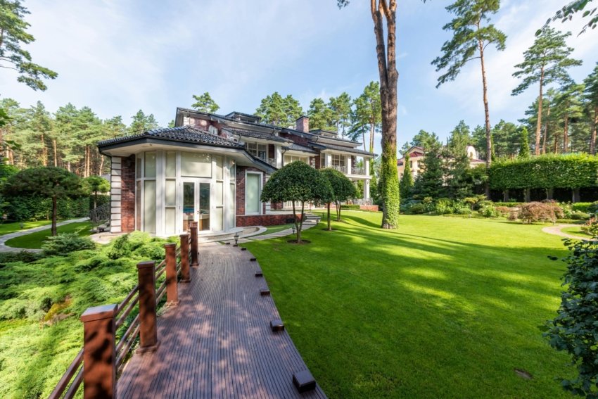 Elegant modern villa surrounded by lush greenery in a tranquil forest setting.